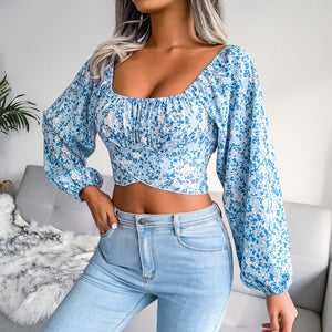 Woman wearing a blue floral top and jeans in a living room setting