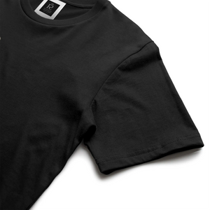 Black streetwear t-shirt featuring small gold crest logo on upper back, minimalist premium design