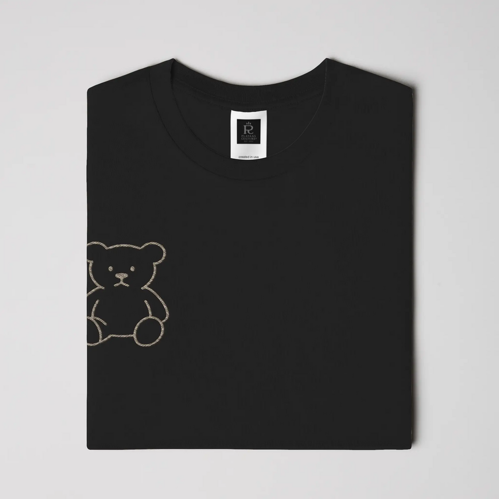 Black streetwear t-shirt featuring small gold crest logo on upper back, minimalist premium design