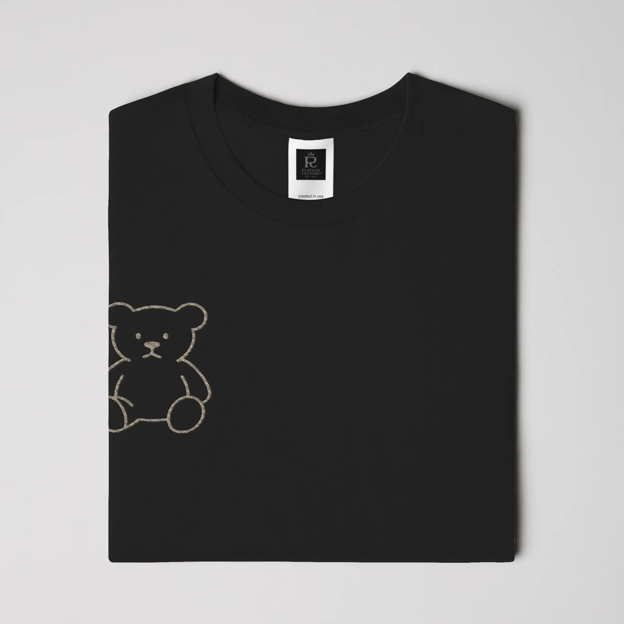 Black streetwear t-shirt featuring small gold crest logo on upper back, minimalist premium design