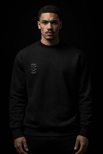 Man wearing a black sweatshirt with a logo on a black background
