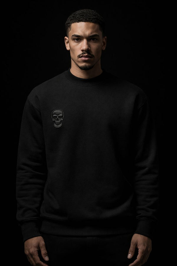 Man wearing a black sweatshirt with a logo on a black background