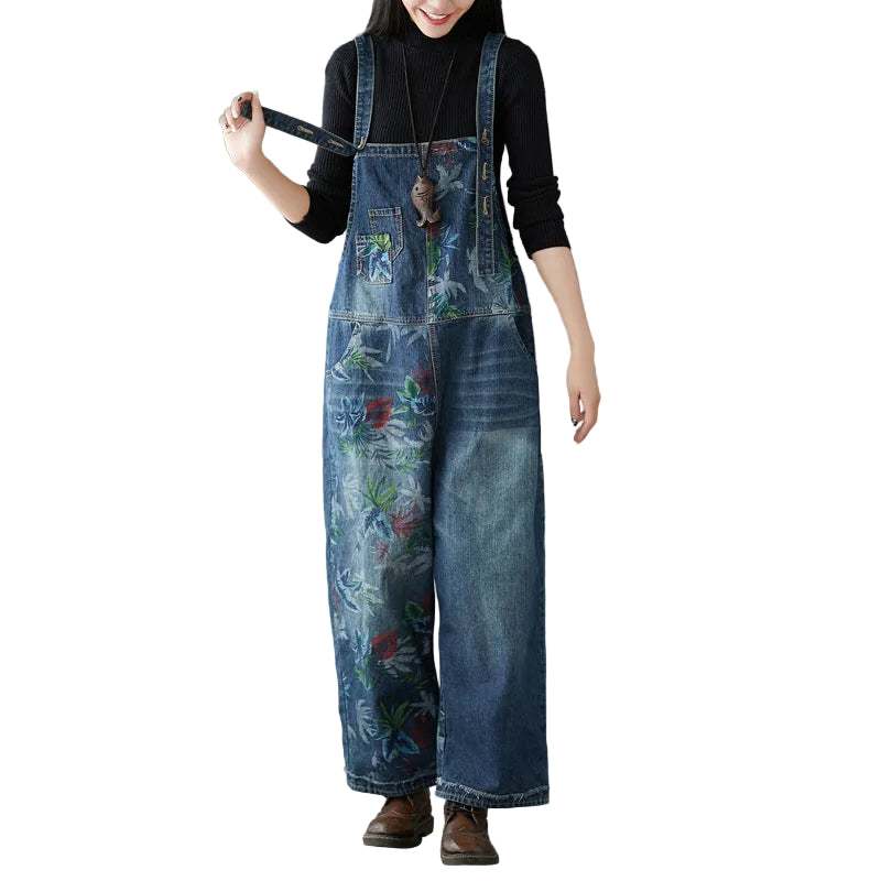 Distressed denim romper with artisanal distressing and adjustable straps in dark blue wash for street style