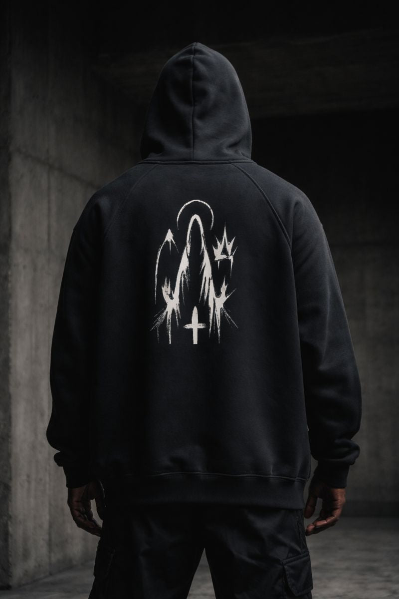 Black premium streetwear hoodie with gold chest crest and symbolic back graphic worn by a Black male model in a minimalist luxury photoshoot.